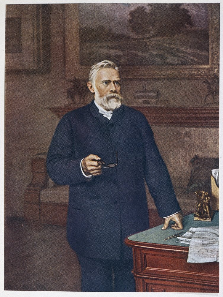 صورة بالأبيض والأسود للعالم والمخترع ألفريد نوبل، مؤسس جائزة نوبل العالمية، وهو ينظر إلى الجانب بجدية وتركيز.