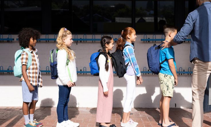 طلاب يقدمون الإذاعة المدرسية بحماس في طابور الصباح، مما يعكس أهمية الانضباط والنظام