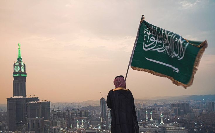 مجموعة من الطلاب السعوديين يقدمون الإذاعة المدرسية بحماس في طابور الصباح احتفالاً باليوم الوطني السعودي